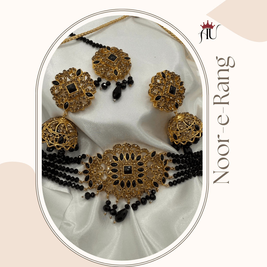 Gold and black jewelry set on a white fabric background with 'Noor-e-Rang' branding.